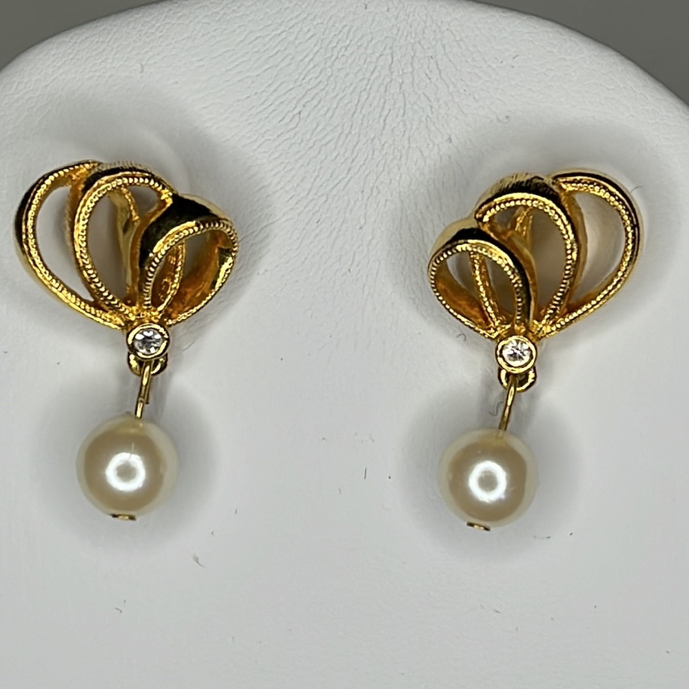 Gold tone ribbon with single drop pearl post back earrings.